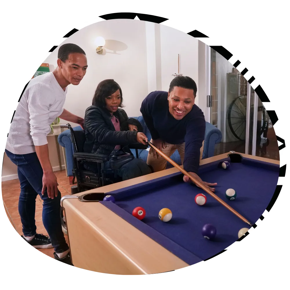 Group of friends, one in wheelchair, playing pool