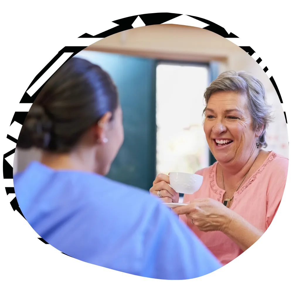 Nurse at home with client, laughing together