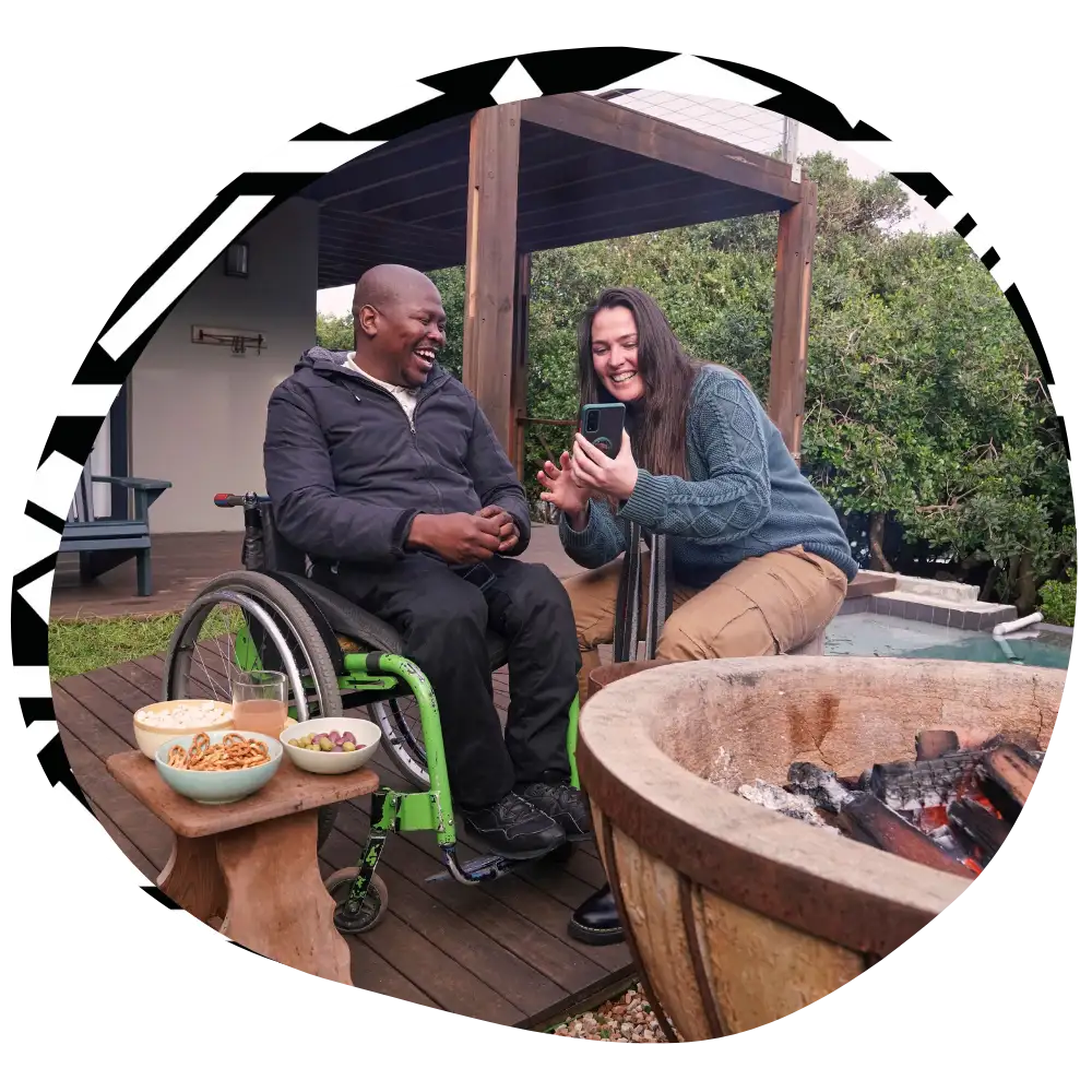 Disabled man in wheelchair smiling with support worker