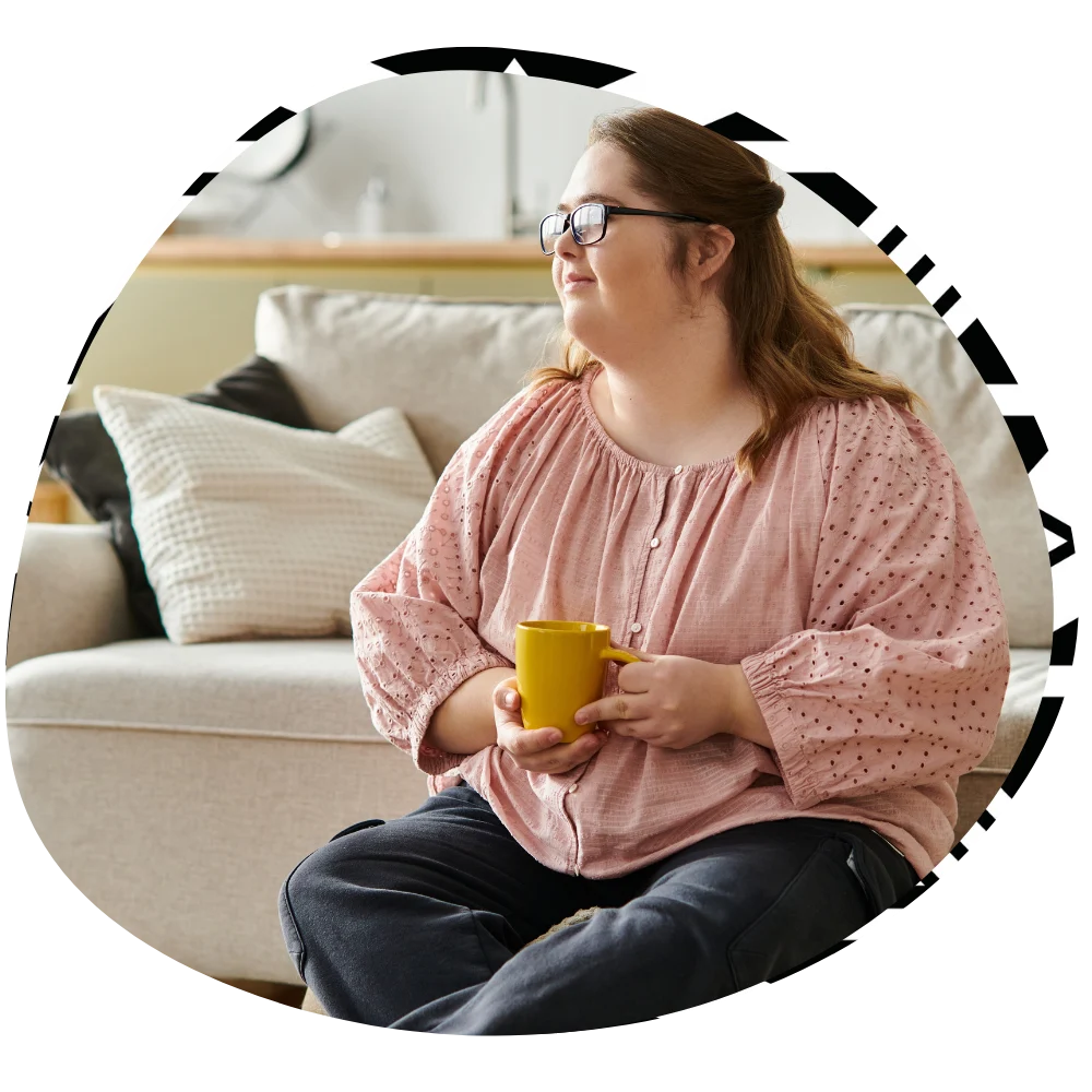 Disabled woman with down syndrome sitting happily in lounge room