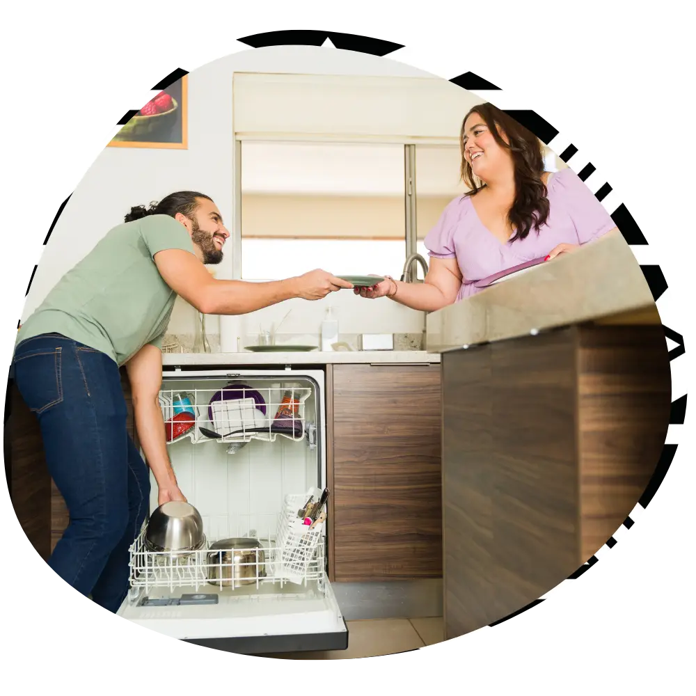 Two support workers unpacking dishwasher